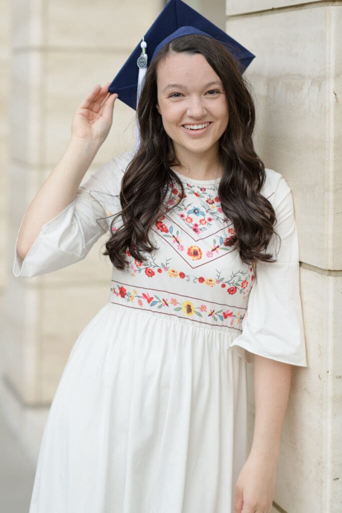 A woman smiles in her cap during her BYU senior portraits