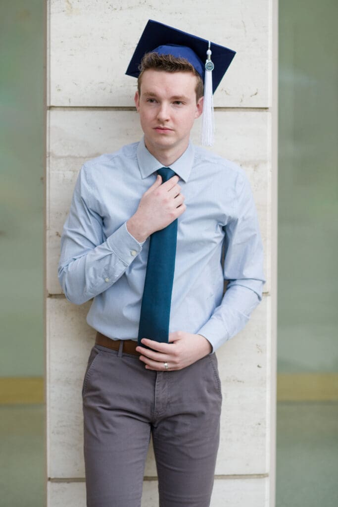 A man straightens his tie during his BYU senior portraits
