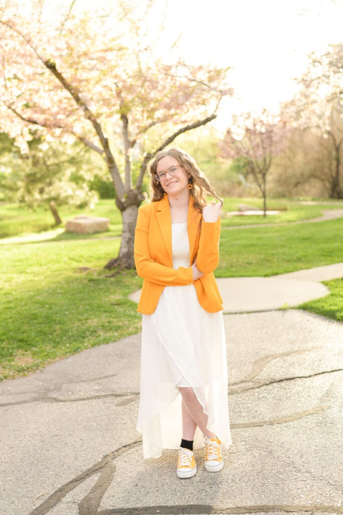 A graduating high school girl smiles during her colorful garden senior session with Salt Lake City photographer Jodi Cornwall Photography.