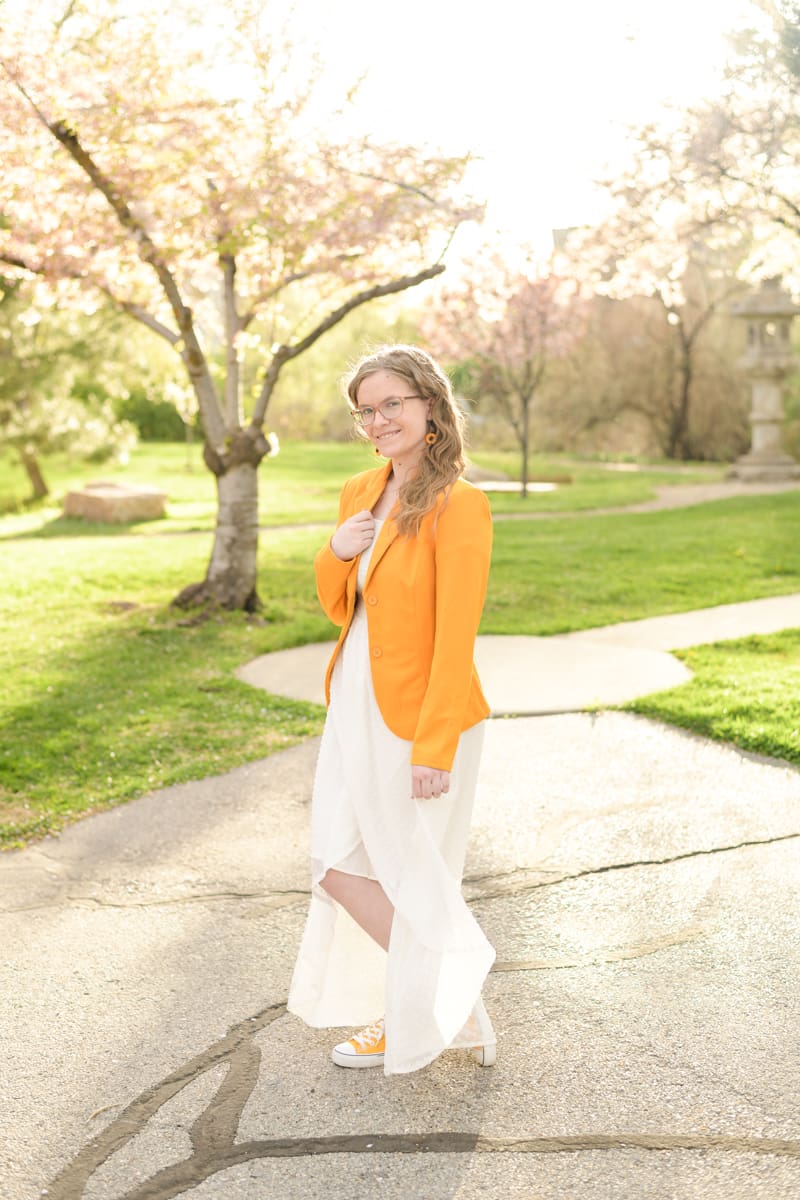 A graduating high school girl smiles during her colorful garden senior session with Salt Lake City photographer Jodi Cornwall Photography.