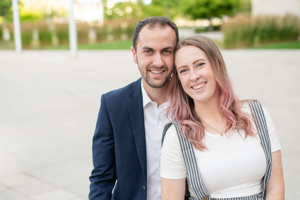 A couple sits close and smiles at the camera during a couples session with Jodi Cornwall Photography