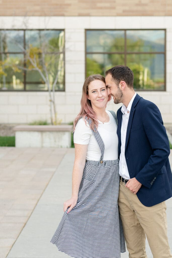 A couple snuggles together smiling with coordinating outfits during their photo session with Jodi Cornwall Photography.