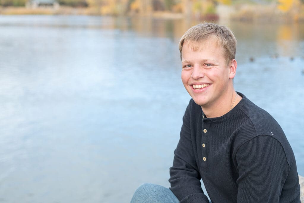 High School senior boy smiling by a pond