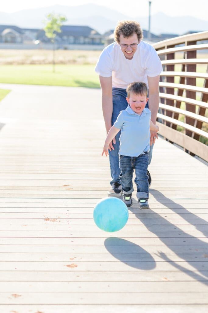 Father chasing a toddler on a bridge