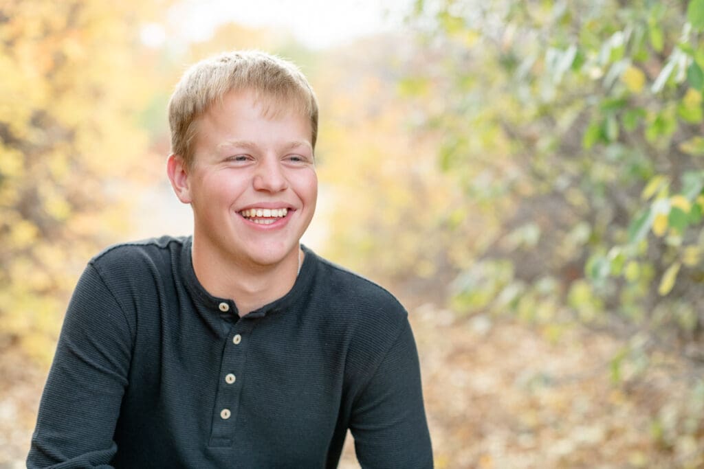 High school senior boy smiling in the fall