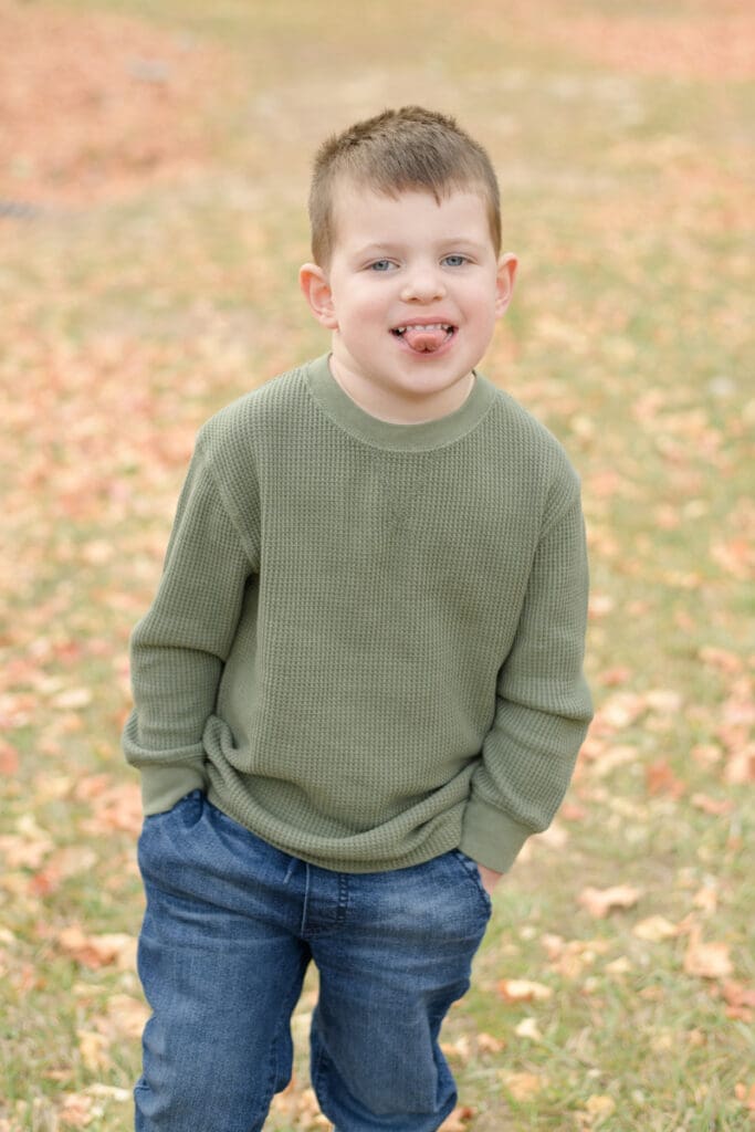Little boy smiling in fall leaves