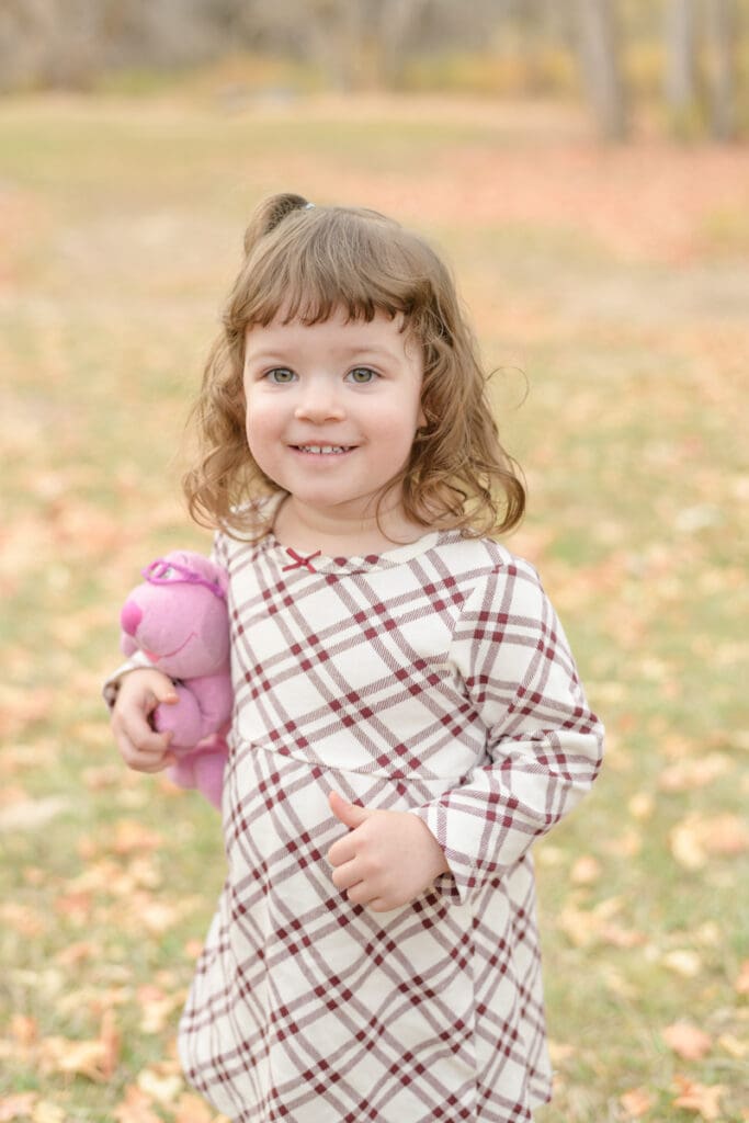 Little girl smiling in fall leaves