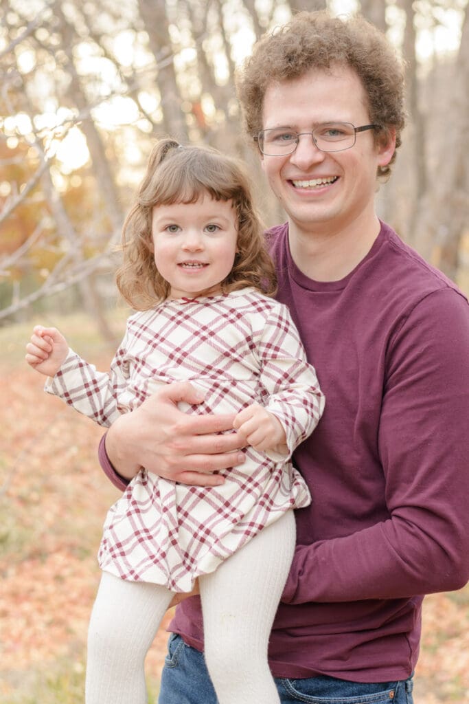 Dad and daughter smiling in fall leaves. Canyon Fall family Session