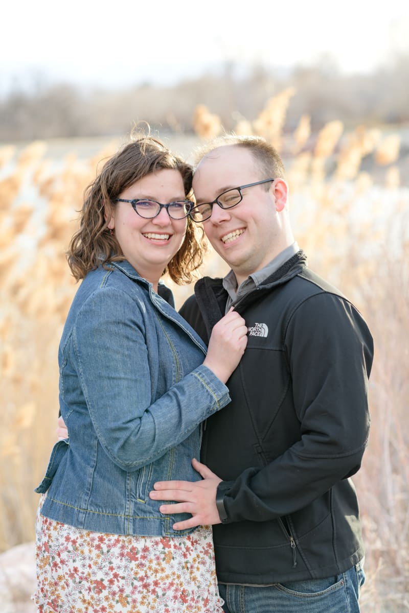 An engaged couple holds each other close and smiles at the camera during their joyful spring engagement session with Salt Lake photographer Jodi Cornwall Photography.