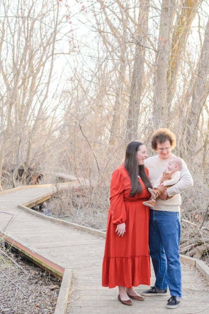 Parents smiling at their small son during a photo session documenting seasons of life.