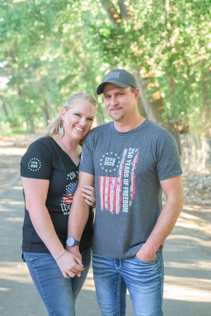 A couple holds each other close while standing on a path while taking family photos in Utah County.