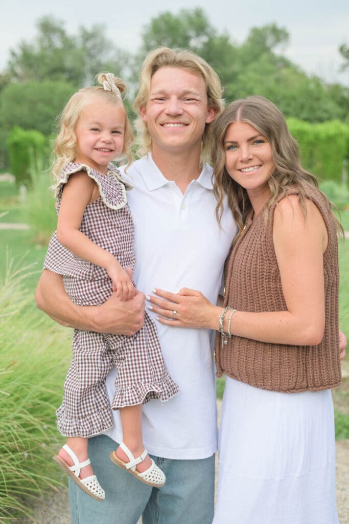 A family of three holds each other close and smiles during an extended family photography session.