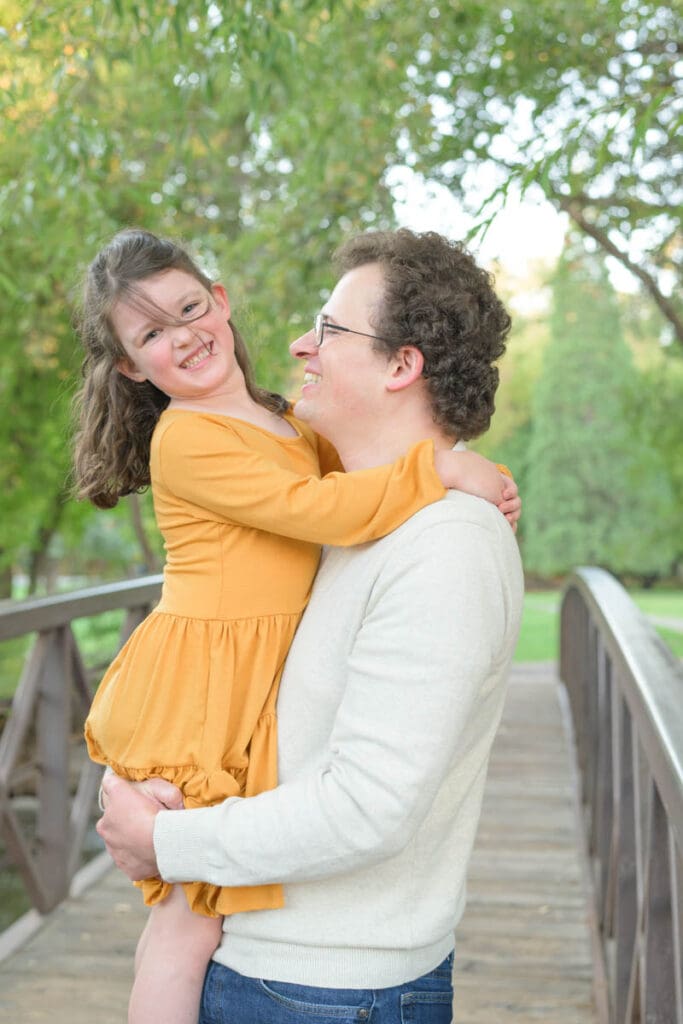 A dad and daughter embrace during fall family photos in Provo, Utah.
